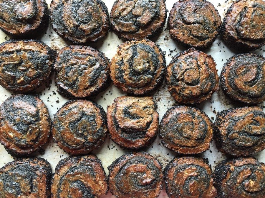 Rows of round pastries swirled with black sesame, cooling on parchment.